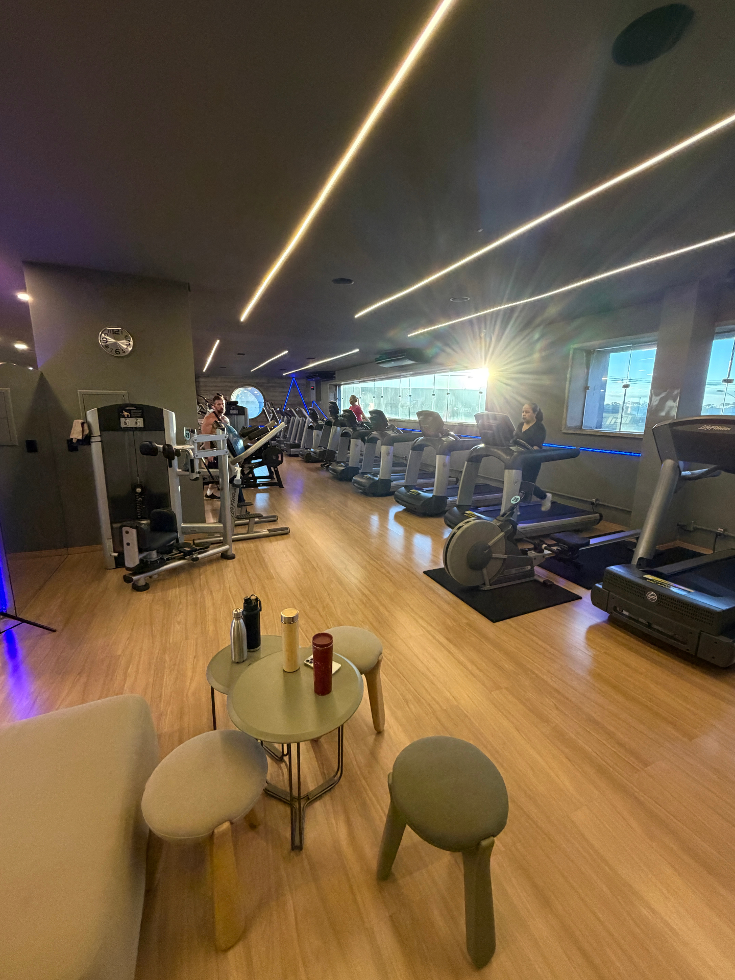 Área cardiovascular com esteiras Life Fitness, lounge e iluminação assinatura
