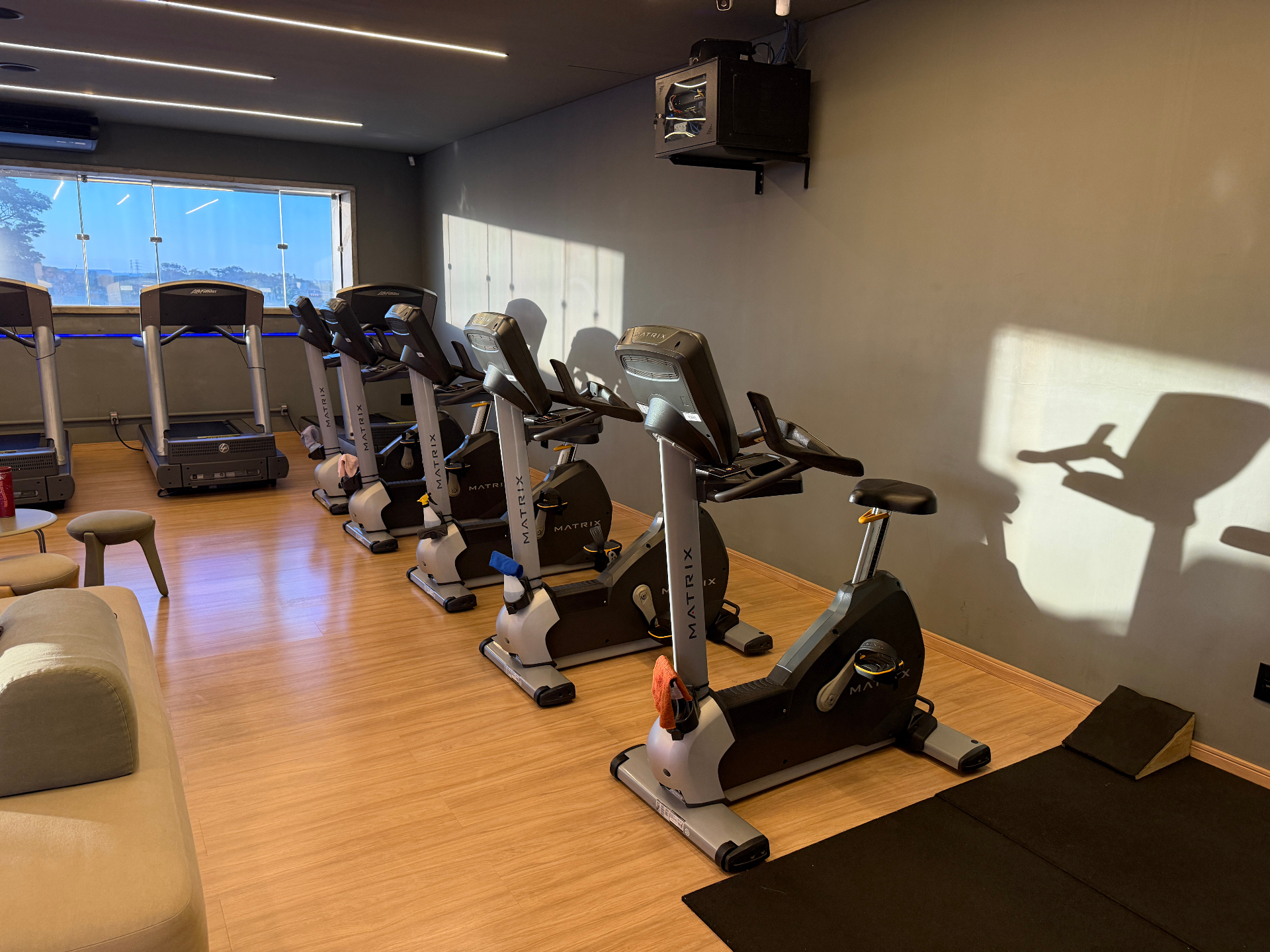 Sala de bikes Matrix e esteiras Life Fitness com lounge na Corpore Rio Preto